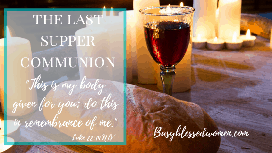 The Last Supper Communion- a loaf of bread and a glass of wine on table with candles in background