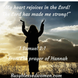 shadowed woman; hands lifted in prayer as she stands outside in a field, sky filled with clouds