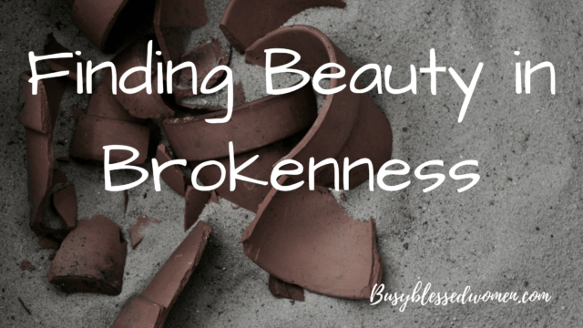 Beauty in Brokenness- shards of broken brown pottery in the sand