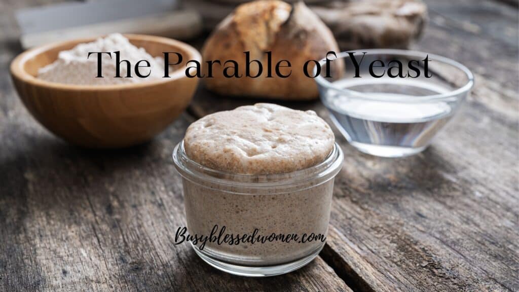 the parable of yeast- small glass bowl full of risen dough, bowl of flour, and small loaf of bread on wooden table