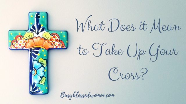What does it mean to take up your cross- multicolored ceramic cross on light blue background