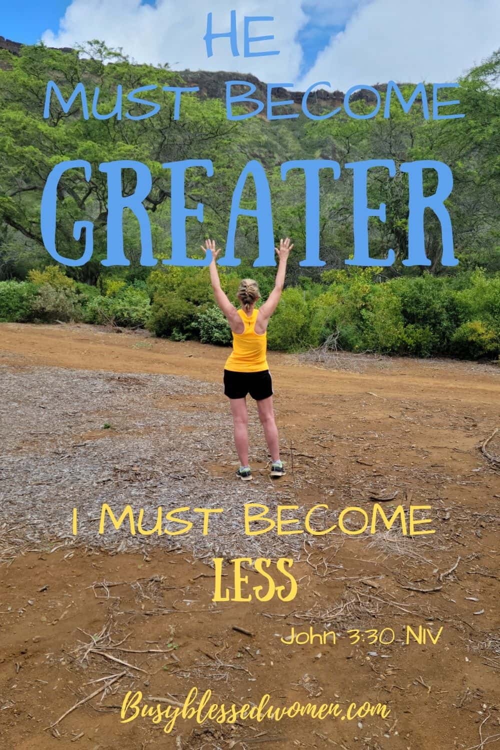 he must increase I must decrease- woman in bright orange sleeveless top and black shorts facing mountain with arms raised