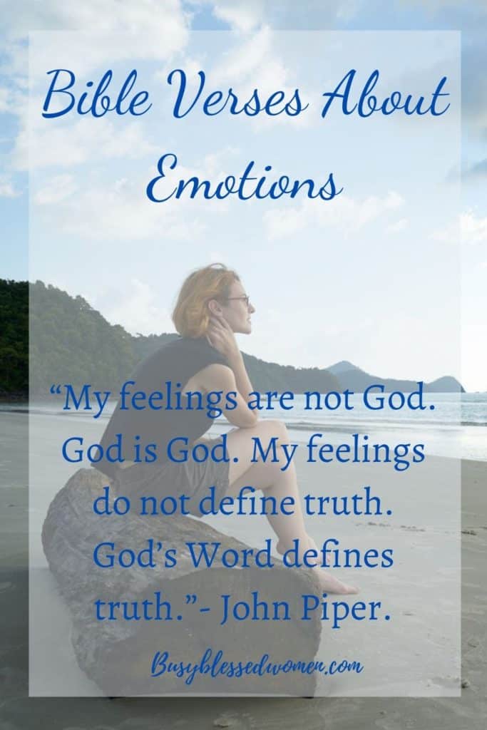 bible verses about emotions- woman in dark tank top and shorts sitting on log on beach with legs crossed, staring into lake