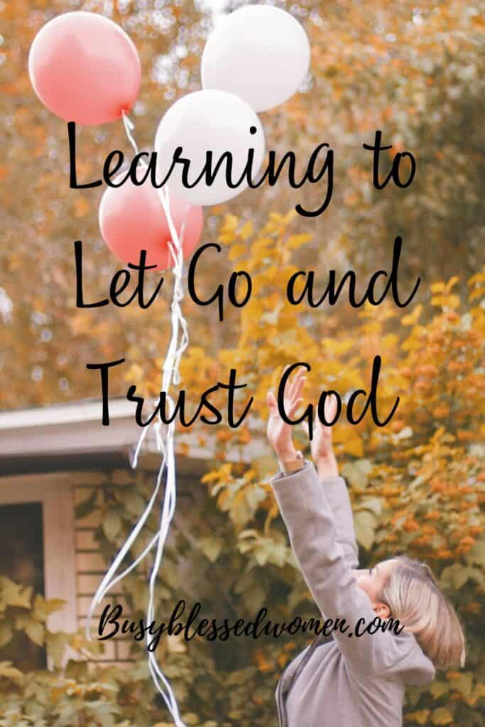 Letting go and trusting God- woman with short blond hair wearing a beige  blazer releasing balloons into sky