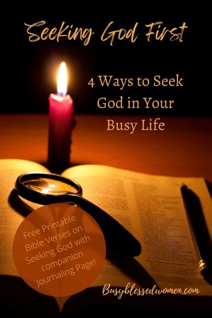 darkened photo of open Bible with magnifying glass and pen on top, lighted red candle nearby