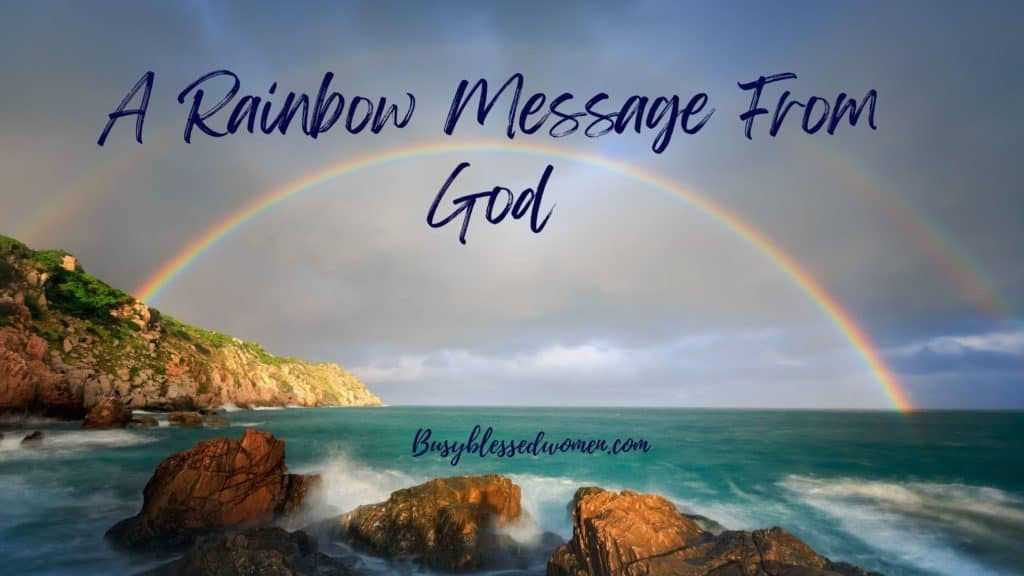 rainbow message from God- full rainbow in cloudy sky over ocean and cliffs