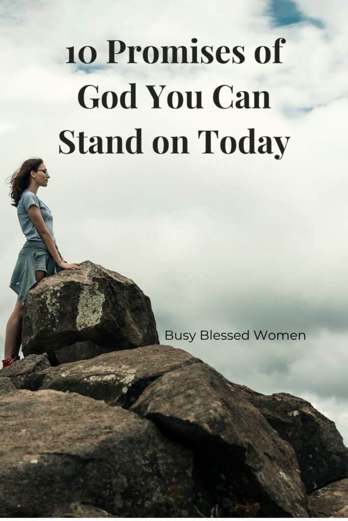 Promises of God- woman in light blue short sleeve shirt, denim shorts, and gray hoodie tied around waist standing next to large rock cloudy sky- background