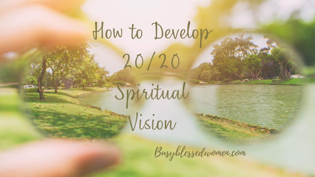 Spiritual Vision- woman's hand holding up circular lens glasses to a blurry background making clear the image of trees and a calm river.