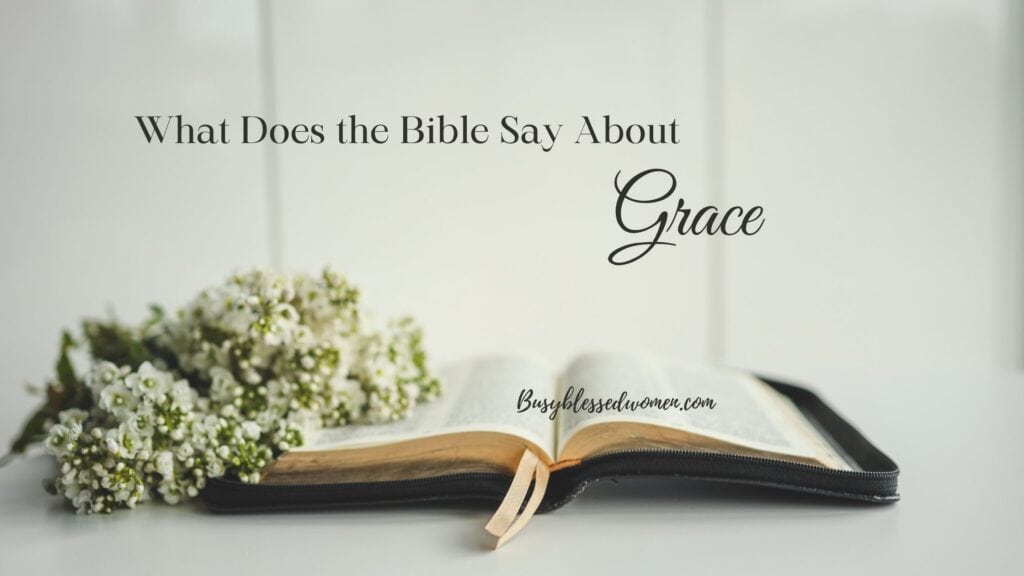 what does the bible say about grace- open bible on white table with spray of tiny white/green flowers on bible